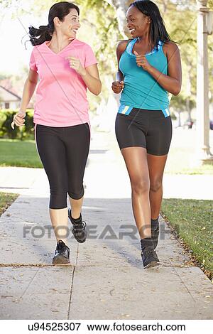 Two Female Runners Exercising On Suburban Street View Large Photo Image Stock Photo - Two Female Runners Exercising On Suburban Street. Fotosearch