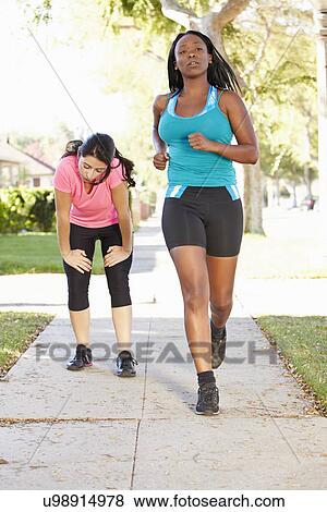 Two Female Runners Exercising On Suburban Street View Large Photo Image Stock Photo - Two Female Runners Exercising On Suburban Street. Fotosearch
