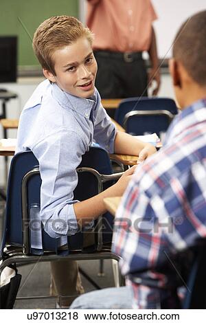 Stock Photo - Two Male Pupils Talking In Class. Fotosearch