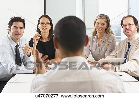 Stock Photo - View From Behind As CEO Addresses Meeting In Boardroom. Fotosearch