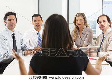 Stock Photo - View From Behind As CEO Addresses Meeting In Boardroom. Fotosearch