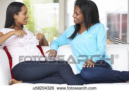 Stock Photograph - Woman Visiting Pregnant Friend At Home. Fotosearch