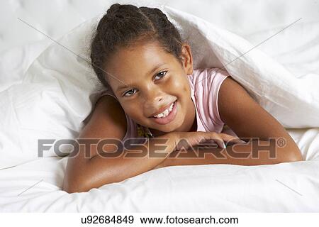 Young Girl Hiding Under Duvet In Bed View Large Photo Image Stock Photo - Young Girl Hiding Under Duvet In Bed. Fotosearch