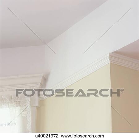 Stock Image - ARCHITECTURAL DETAILS: Picture rail molding, near window trim work, Victorian, painted white trim, pale yellow walls,. Fotosearch