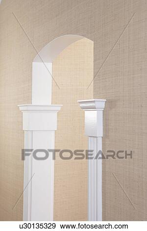Stock Photo - ARCHITECTURAL DETAILS: Sea grass cloth wallpaper with white pilaster casing trim work in Neo-classical fluted design comes 3/4 way up jam, arched doorway. light wheat color. Fotosearch