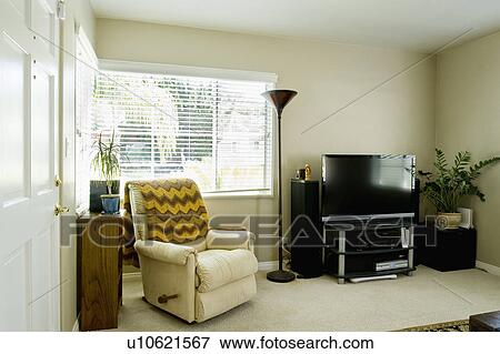 Stock Photo - Armchair and entertainment center in living room, San Diego, California, United States of America. Fotosearch