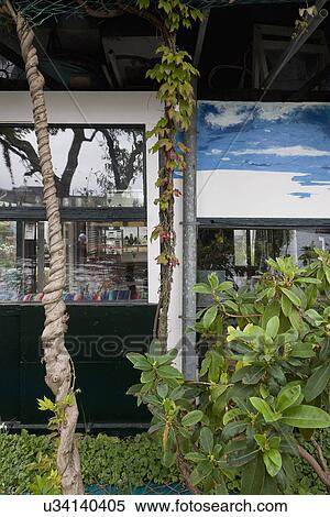 Stock Photography - Back yard of cottage with plants and painting. Fotosearch
