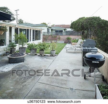 Barbecue grill, potted plants and lounge chairs in yard View Large Photo Image Stock Image - Barbecue grill, potted plants and lounge chairs in yard. Fotosearch