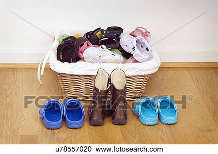 Stock Image - Basket of children's shoes on hardwood floor; Potomac; Maryland; USA. Fotosearch