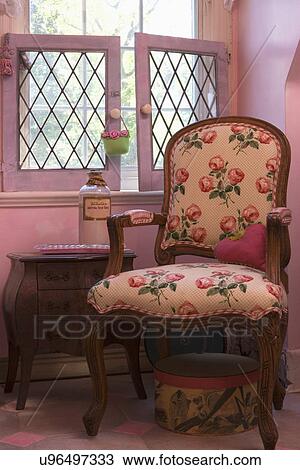BATHROOM: Pink small bath, Louis style chair with floral rose pattern fabric, hat box below, leaded glass window View Large Photo Image Stock Image - BATHROOM: Pink small bath, Louis style chair with floral rose pattern fabric, hat box below, leaded glass window. Fotosearch