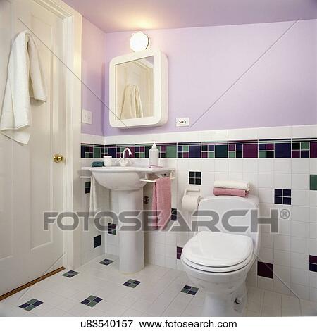 Stock Photo - BATHROOMS - Contemporary bath in lavender and white with pedestal sink, partial tiled wall with checkered pattern in green, violet and purple, wall mounted medicine cabinet, door with towel, toilet . Fotosearch