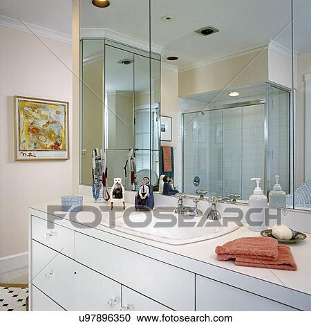 Stock Image - BATHROOMS: Contemporary laminate vanity area with wall mirror.. Fotosearch