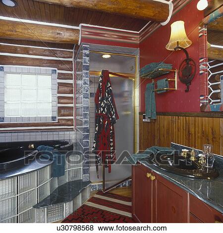 BATHROOMS: Western style, log wall above bath tub, beadboard partial wall behind black sink, glass block window and tub surround shower, red walls, western wall sconce, wainscoat View Large Photo Image Stock Photo - BATHROOMS: Western style, log wall above bath tub, beadboard partial wall behind black sink, glass block window and tub surround shower, red walls, western wall sconce, wainscoat . Fotosearch