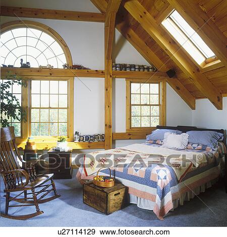 BEDROOMS: Arched window, skylights, rocking chair, quilts, shaker boxes, carpet, pine posts and beams, beer stein collection on ledges. View Large Photo Image Stock Photo - BEDROOMS: Arched window, skylights, rocking chair, quilts, shaker boxes, carpet, pine posts and beams, beer stein collection on ledges.. Fotosearch