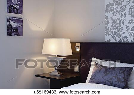 Bedside lamp on night table by bed View Large Photo Image Stock Image - Bedside lamp on night table by bed. Fotosearch