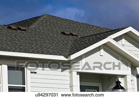 Stock Image - Black shingles on roof of traditional home. Fotosearch