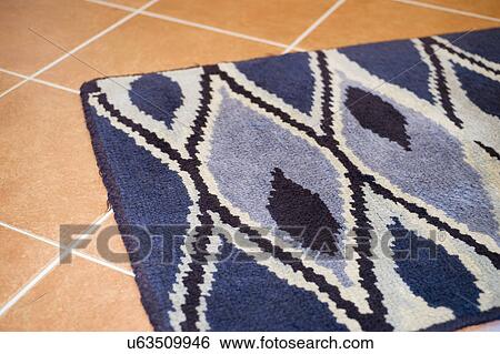 Stock Photograph - Blue rug on ceramic tile; Italy. Fotosearch