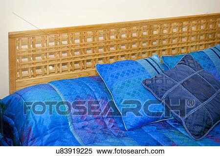 Stock Photography - Blue throw pillows on bed; Italy. Fotosearch