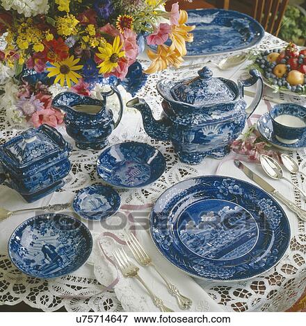 Stock Photo - Blue transfer ware with lace tablecloth and flowers on table. Fotosearch
