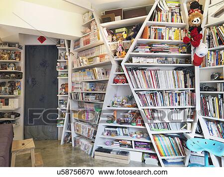 Stock Image - Books on floor to ceiling shelves in apartment. Fotosearch