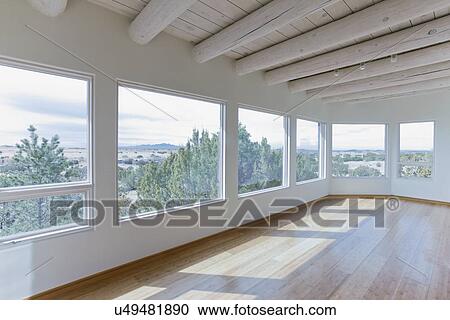 Stock Image - Ceiling beams and hardwood floor in home with scenic views, Santa Fe, New Mexico, USA. Fotosearch
