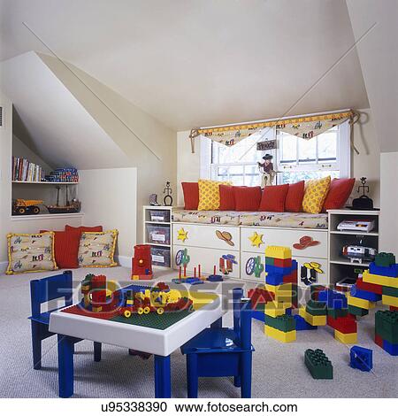 Stock Image - CHILDREN'S BEDROOM: Playhouse in attic with windows, raised day bed, drawers underneath. Legos table, Western theme, primary colors, pillows.. Fotosearch
