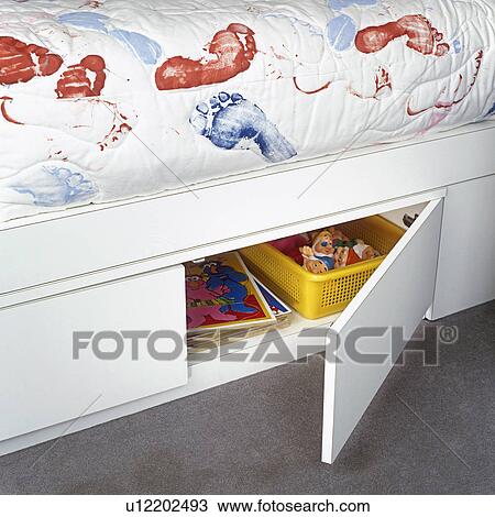 Stock Image - CHILDREN'S BEDROOM: White bed with storage area beneath. Bedspread with red and blue hand and foot print pattern.. Fotosearch
