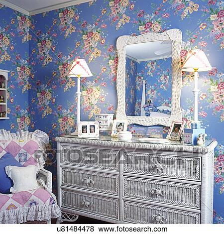 CHILDREN'S BEDROOM: White wicker bureau and chair. Very elaborate floral continuous blue and pink wallpaper. Pictured frames spread out on glass top of bureau. View Large Photo Image Stock Photo - CHILDREN'S BEDROOM: White wicker bureau and chair. Very elaborate floral continuous blue and pink wallpaper. Pictured frames spread out on glass top of bureau.. Fotosearch