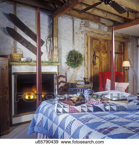 CHRISTMAS - Reproduction four poster bed, wing chair, gas fireplace, swamp skis on wall, blue and white quilt on bed, rustic, plaster walls, exposed beams, fresh wreath, redwing chair, View Large Photo Image Stock Photo - CHRISTMAS - Reproduction four poster bed, wing chair, gas fireplace, swamp skis on wall, blue and white quilt on bed, rustic, plaster walls, exposed beams, fresh wreath, redwing chair,. Fotosearch