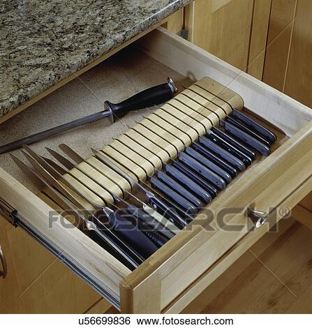 Stock Photograph - close up detail of knife drawer in maple cabinet, and granite counter top. Fotosearch