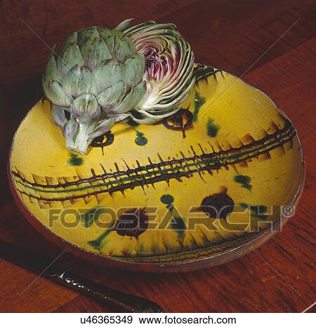 Close-up of artichoke in plate with knife on table View Large Photo Image Stock Photo - Close-up of artichoke in plate with knife on table. Fotosearch