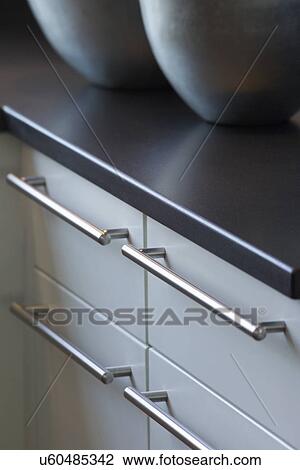 Stock Image - Close-up of drawer handles of kitchen cabinets. Fotosearch