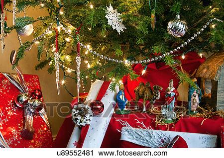 Stock Image - Close-up of gift boxes with decorated Christmas tree. Fotosearch