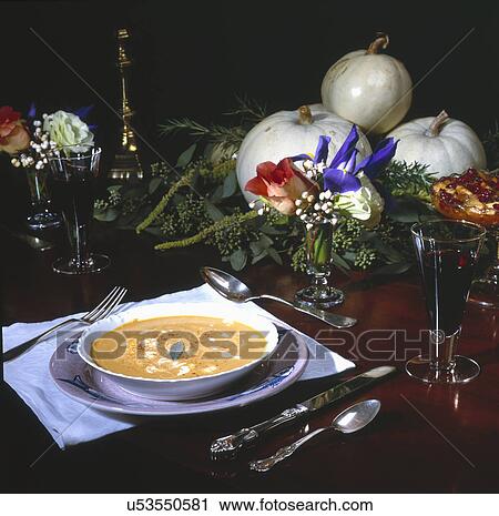 Stock Image - Close-up of soup and wineglasses on dining table. Fotosearch