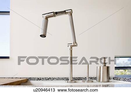 Stock Image - Close-up of stainless steel faucet and soap dispenser on counter, San Diego, California, USA. Fotosearch