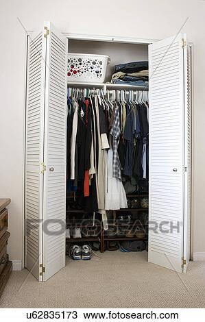Stock Image - Clothes and shoes in closet, San Diego, California, United States of America. Fotosearch