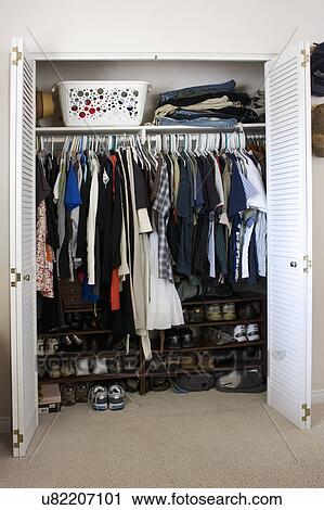 Stock Image - Clothes and shoes in cluttered closet, San Diego, California, United States of America. Fotosearch