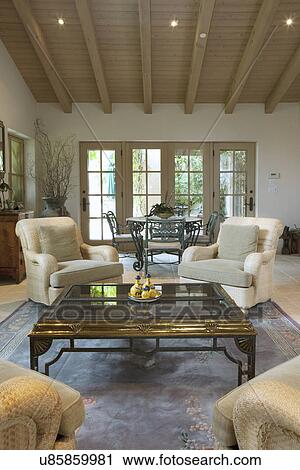 Stock Image - Coffee table and armchairs in traditional living room, California, USA. Fotosearch
