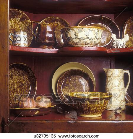 COLLECTIBLES - Brown Sponge ware Collection displayed in corner cabinet. View Large Photo Image Stock Photography - COLLECTIBLES - Brown Sponge ware Collection displayed in corner cabinet. . Fotosearch