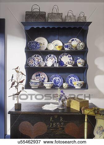 COLLECTION - Blue wall display cupboard with Leeds, Gaudy Dutch, Salopian dishes, painted 1820's antique trunk with hearts, folk art birds on wire tree, set of metal woven baskets, View Large Photo Image Stock Photo - COLLECTION - Blue wall display cupboard with Leeds, Gaudy Dutch, Salopian dishes, painted 1820's antique trunk with hearts, folk art birds on wire tree, set of metal woven baskets,. Fotosearch