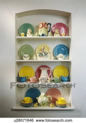 Stock Photograph - COLLECTION - Collection of pastel dishes on white shelves. . Fotosearch