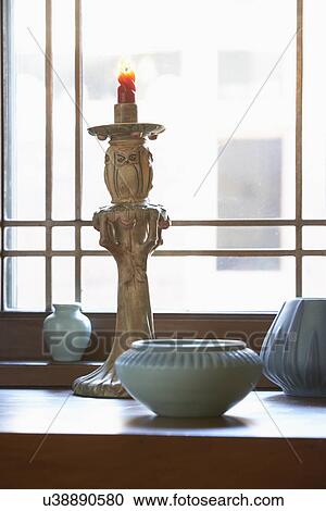 Stock Image - COLLECTION DISPLAY: blue matte finish Van Briggle pottery, Roseville candlestick in window sill display. Fotosearch