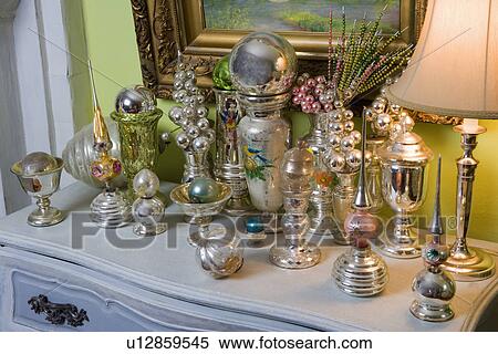 Stock Photography - COLLECTION DISPLAY: Mercury glass vases, Christmas ornaments, tree toppers, beaded picks, on table top. Fotosearch