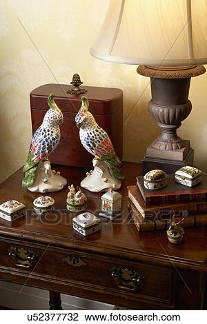 Stock Image - COLLECTION DISPLAY: Miniature ceramic box collection, books, urn lamp, ceramic birds, covered box. Fotosearch