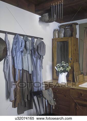 COLLECTION DISPLAYS - 1850's aprons and bonnets hang from a herb drying rack in kitchen. Early American style in a new home. View Large Photo Image Stock Photography - COLLECTION DISPLAYS - 1850's aprons and bonnets hang from a herb drying rack in kitchen. Early American style in a new home. . Fotosearch