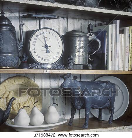 COLLECTION DISPLAYS: An assortment of antiques, three white stone pears, antique golf award, pewter mug, old metal cow, beeswax mold, cookbooks, close up View Large Photo Image Stock Image - COLLECTION DISPLAYS: An assortment of antiques, three white stone pears, antique golf award, pewter mug, old metal cow, beeswax mold, cookbooks, close up . Fotosearch