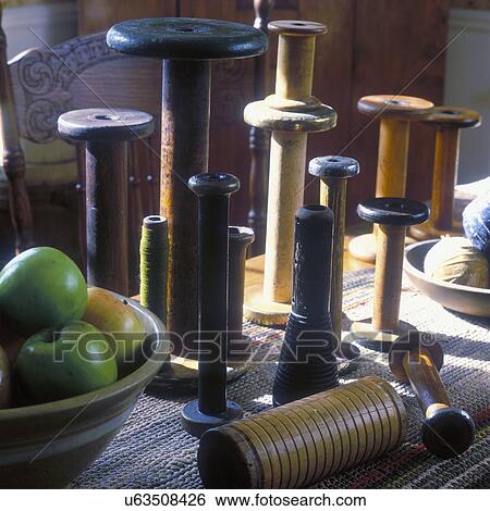 Stock Photograph - COLLECTION DISPLAYS - Country, antique spools, close up detail of farm table display, green apples in wood bowl, sunlit. Fotosearch