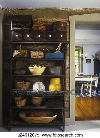 Stock Photography - COLLECTION DISPLAYS - Rustic Country interior in log home with collection of baskets, yellow ware, band boxes displayed on rustic shelves in hall. . Fotosearch