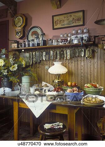 COLLECTION DISPLAYS: Sideboard set with vintage serving bowls, oil lamp set, brass scale collection on wall, electrified antique lamp, ball jar canisters, vintage mixing bowls filled with fresh fruit, baked pie, whipped cream, wainscot, nostalgic View Large Photo Image Stock Image - COLLECTION DISPLAYS: Sideboard set with vintage serving bowls, oil lamp set, brass scale collection on wall, electrified antique lamp, ball jar canisters, vintage mixing bowls filled with fresh fruit, baked pie, whipped cream, wainscot, nostalgic . Fotosearch