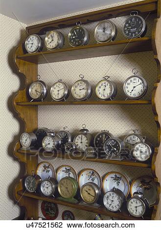 Stock Image - COLLECTION DISPLAYS: Vintage and antique wind up alarm clocks on pine shelving.. Fotosearch